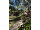 Landscaped front yard with lush greenery and mature trees at 1415 Winding Oak Dr, Port Charlotte, FL 33948