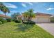 Single-story house with a red tile roof, palm trees, and a brick driveway at 14173 Myakka Pointe Dr, Port Charlotte, FL 33953