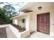 Side view of home showcasing a wooden door and landscaping at 1600 Thomas St, Englewood, FL 34223