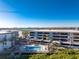 An aerial view of the condo building and the pool with blue skies in the background at 1701 Beach Rd # 404, Englewood, FL 34223