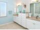 Double vanity bathroom with light blue walls and neutral tile floors at 1901 Illinois Ave, Englewood, FL 34224