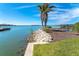 Scenic waterfront view with palm trees and grassy area at 1901 Illinois Ave, Englewood, FL 34224