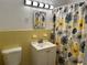 Bathroom with yellow tile and floral shower curtain at 21179 Glendale Ave, Port Charlotte, FL 33952