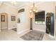 Elegant foyer featuring a chandelier, decorative wall, and rug at 214 W Pine Valley Ln, Rotonda West, FL 33947