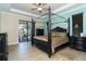 Spacious main bedroom with a large four-poster bed and access to the outside at 214 W Pine Valley Ln, Rotonda West, FL 33947