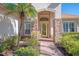 Front entry with stone accents, arched entryway, and yellow door at 2619 Myakka Marsh Ln, Port Charlotte, FL 33953