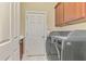 Laundry room with washer, dryer, and built-in cabinets at 2619 Myakka Marsh Ln, Port Charlotte, FL 33953