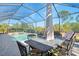 Relaxing poolside patio with table and chairs under a covered patio at 2619 Myakka Marsh Ln, Port Charlotte, FL 33953