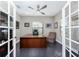 Bright home office features a large desk, ceiling fan, and hardwood floors at 26744 Weiskopf Dr, Englewood, FL 34223