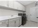 Bright laundry room with white cabinets and a washer and dryer at 26744 Weiskopf Dr, Englewood, FL 34223