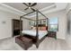 Luxurious main bedroom with four-poster bed and tray ceiling at 26744 Weiskopf Dr, Englewood, FL 34223