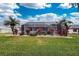 Landscaped backyard featuring a large, screened pool at 276 Long Meadow Ln, Rotonda West, FL 33947