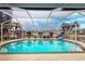 Relaxing screened pool with a basketball hoop and view of the canal at 276 Long Meadow Ln, Rotonda West, FL 33947