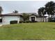 Single-story home with a landscaped lawn and attached garage at 294 Rotonda Cir, Rotonda West, FL 33947