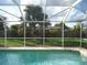 Refreshing pool with screened enclosure and backyard view at 3159 Pinetree St, Port Charlotte, FL 33952