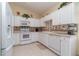 Bright kitchen features white cabinetry, appliances and a lovely decorative backsplash at 3323 Grand Vista Ct # 201, Port Charlotte, FL 33953