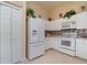 Bright kitchen featuring white appliances, white cabinets, and neutral tile backsplash at 3323 Grand Vista Ct # 201, Port Charlotte, FL 33953