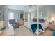 Spacious main bedroom with a comfortable four-poster bed and an armchair at 367 Englewood Isles Pkwy # 4, Englewood, FL 34223