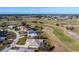 An aerial view of a home featuring a screened-in lanai, complemented by lush landscaping, all situated on a golf course at 40 Bunker Pl, Rotonda West, FL 33947