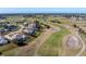 An aerial view of a single-Gathering home situated on a golf course with a screened-in lanai and lush landscaping at 40 Bunker Pl, Rotonda West, FL 33947