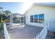 View of the back patio featuring a screened-in lanai and a bright white fence at 40 Bunker Pl, Rotonda West, FL 33947