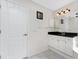 Bathroom with a black granite countertop vanity, ceramic tile flooring, and white door at 40 Bunker Pl, Rotonda West, FL 33947