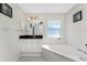 Bright bathroom featuring a soaking tub, granite countertop vanity, and tile flooring at 40 Bunker Pl, Rotonda West, FL 33947