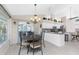 Bright dining area near the kitchen with a modern chandelier, golf course and pool view at 40 Bunker Pl, Rotonda West, FL 33947