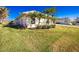 The well-maintained lawn is accented by garden beds with palm trees flanking the side of this single story home at 40 Bunker Pl, Rotonda West, FL 33947