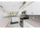 Bright kitchen featuring white cabinetry, stainless steel appliances, and stylish tile backsplash at 40 Bunker Pl, Rotonda West, FL 33947