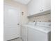 A bright laundry room with a washer, dryer, and white storage cabinets at 40 Bunker Pl, Rotonda West, FL 33947