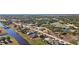 Aerial view of a single Gathering home located on a canal with lush landscaping at 411 Boundary Blvd, Rotonda West, FL 33947