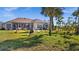 Home's back view, showing patio and yard at 411 Boundary Blvd, Rotonda West, FL 33947