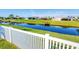 Water view from backyard with a white picket fence and manicured green grass, providing a serene outdoor space at 429 Rotonda Cir, Rotonda West, FL 33947