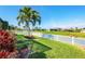 Beautiful backyard overlooking the canal, framed by palm trees and manicured landscaping at 429 Rotonda Cir, Rotonda West, FL 33947