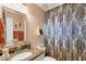 Bathroom with granite countertop, decorative mirror, patterned shower curtain, and updated fixtures at 429 Rotonda Cir, Rotonda West, FL 33947