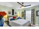 Bright bedroom featuring colorful decor, a ceiling fan, and a window with patterned curtains at 429 Rotonda Cir, Rotonda West, FL 33947