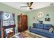 Cozy living room featuring a blue sofa, eclectic decor, and a vintage-style armoire at 429 Rotonda Cir, Rotonda West, FL 33947