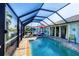 Relaxing screened pool with a brick-paved lanai, a red umbrella, and access to the living room at 429 Rotonda Cir, Rotonda West, FL 33947