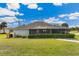 Home's backyard with screened enclosure and landscaped yard at 497 Rotonda Cir, Rotonda West, FL 33947