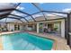 Relaxing pool and patio with covered lanai and outdoor dining area at 497 Rotonda Cir, Rotonda West, FL 33947