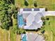 An aerial view of home with gray roof featuring a screened pool and solar panels at 52 Marker Rd, Rotonda West, FL 33947