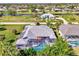 Aerial view of stunning home with a private screened in pool, solar panels, lush lawns and lake views at 52 Marker Rd, Rotonda West, FL 33947