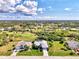 Aerial view of a well-maintained home in a desirable neighborhood with lush greenery and a golf course at 52 Marker Rd, Rotonda West, FL 33947