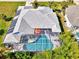 Aerial view of home featuring a screened in private pool, solar panels and well maintained roof at 52 Marker Rd, Rotonda West, FL 33947