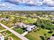 Breathtaking aerial view of a home in a community with golf course, mature trees, and blue skies at 52 Marker Rd, Rotonda West, FL 33947