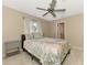 Cozy bedroom showcases a ceiling fan, side table, bed with linens, and a large window at 52 Marker Rd, Rotonda West, FL 33947