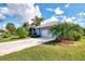 Charming single-story home with a well-manicured lawn and lush tropical landscaping at 52 Marker Rd, Rotonda West, FL 33947