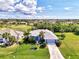 Well-maintained single-story home with a pristine lawn, neatly trimmed shrubbery, and a long paved driveway at 52 Marker Rd, Rotonda West, FL 33947