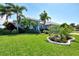 Charming home with lush green lawn, tropical palms, and vibrant landscaping offering great curb appeal at 52 Marker Rd, Rotonda West, FL 33947